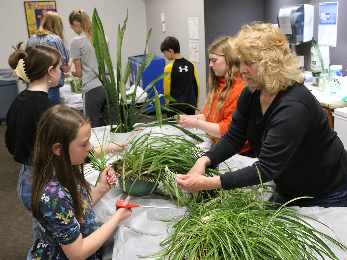 Pictured is Extension Associate Mary Jane Frogge teaching Horticulture 4-H Club members how to propagate plants.