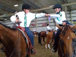 Pictured are youth congratulating each other at a horse show. 
