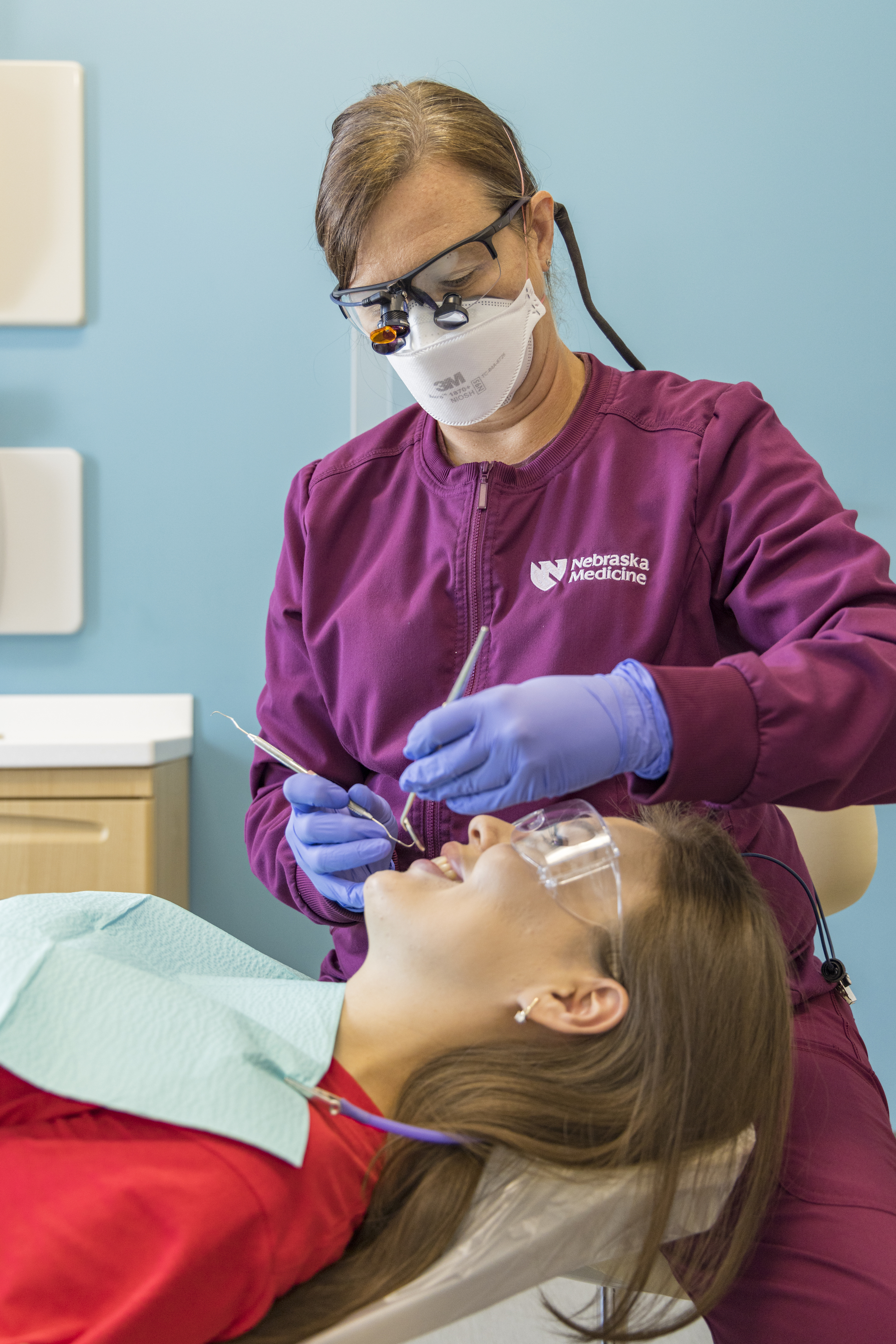 dentist performing a dental exam on a student