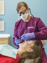 dentist performing a dental exam on a student