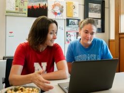 CAST Director, Lori Romano meeting with a student and looking at a laptop during a coaching session