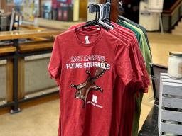 T-shirts hang in the Nebraska Maps & More store. 