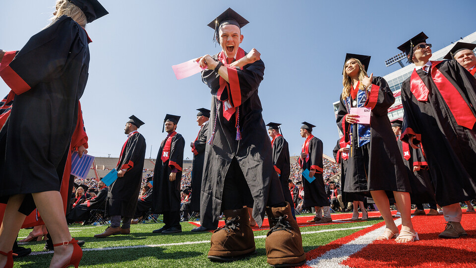 Craig Chandler | University Communication and Marketing Brendan Kauth-Fisher “throws the bones” while waiting to receive his Bachelor of Science in Business Administration during the undergraduate commencement ceremony May 20 at Memorial Stadium. He has b