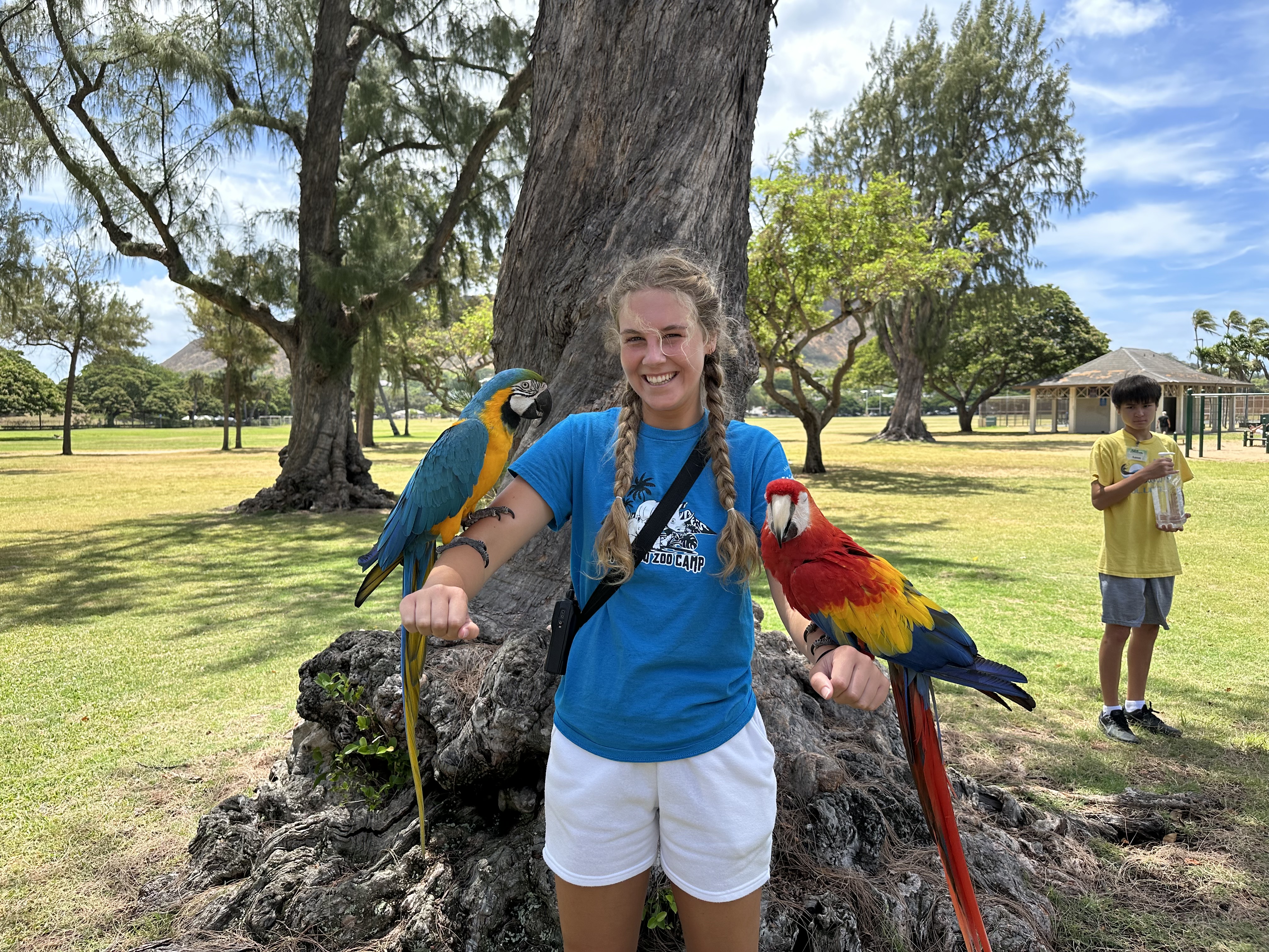Emily Nelson with two macaws in Hawaii