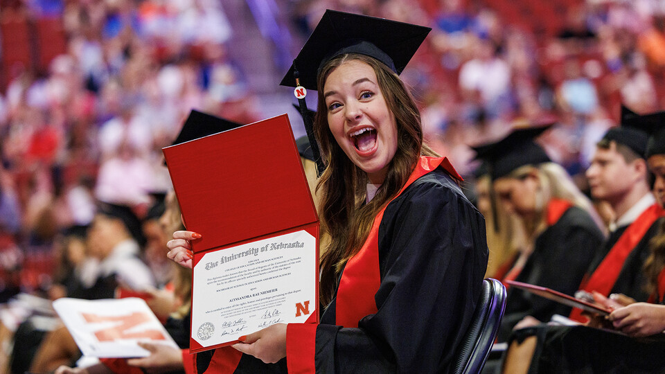 Alyssandra Niemeier shows off her newly earned degree during the combined graduate and undergraduate commencement ceremony Aug. 12 at Pinnacle Bank Arena.