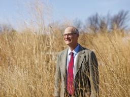 Robert Brooke standing in a field of wheat.