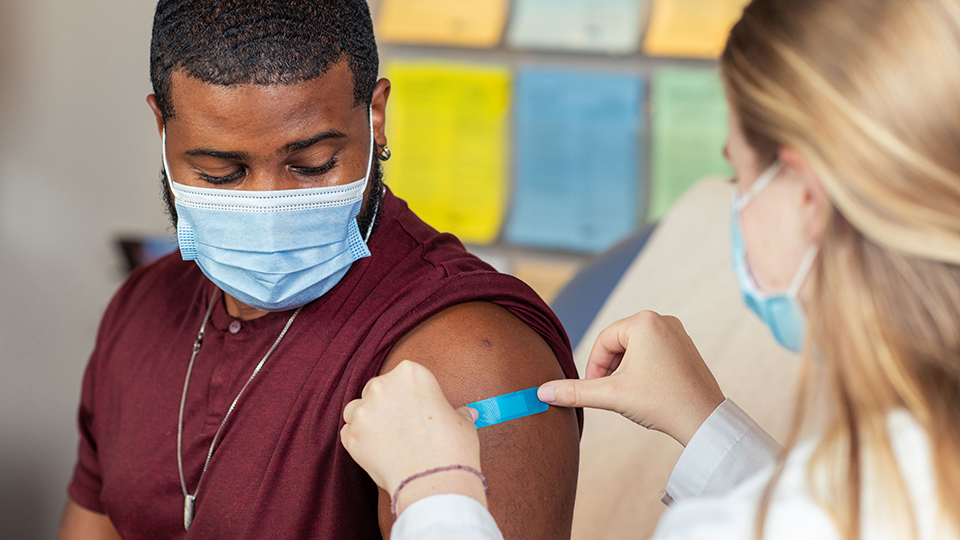 A band-aid is applied to a student's arm after a shot. (courtesy image)