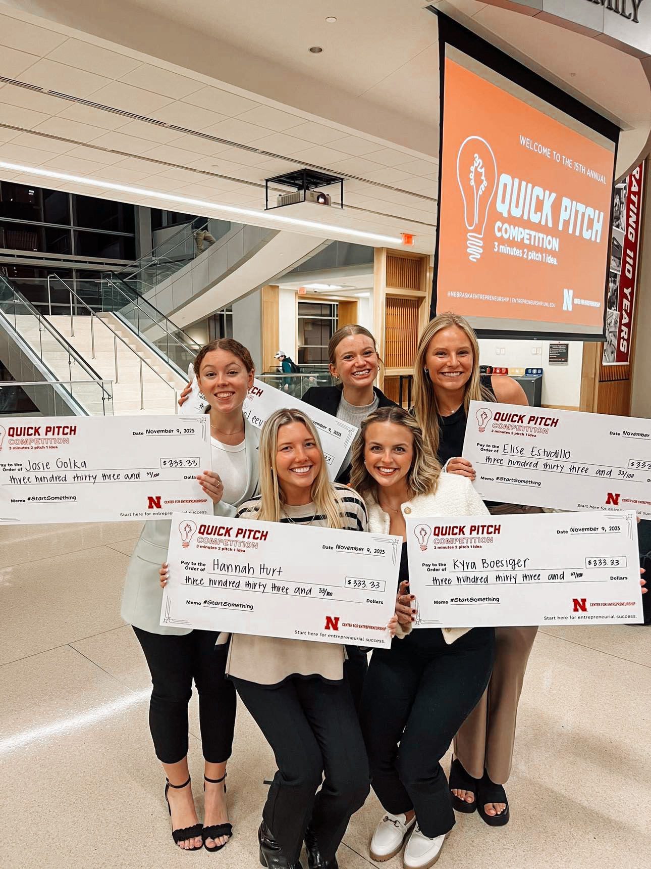 Five students pose with their checks after being a 3-2-1 Quick Pitch winner in their respective room