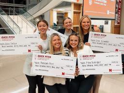 Five students pose with their checks after being a 3-2-1 Quick Pitch winner in their respective room