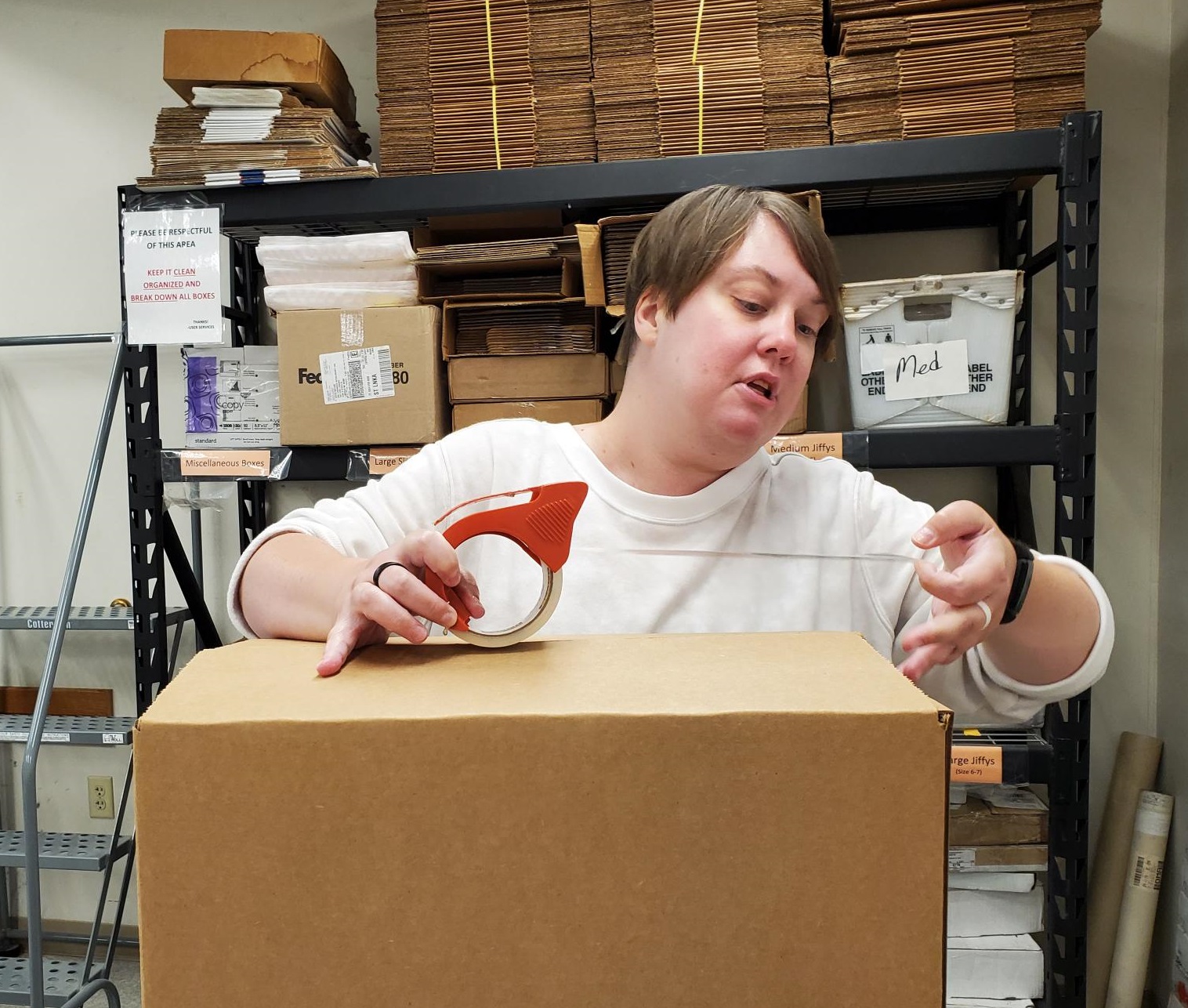 Lauren Stewart, Libraries mail associate, packs one of the boxes of journal volumes being sent to the Big Ten shared print repository. 