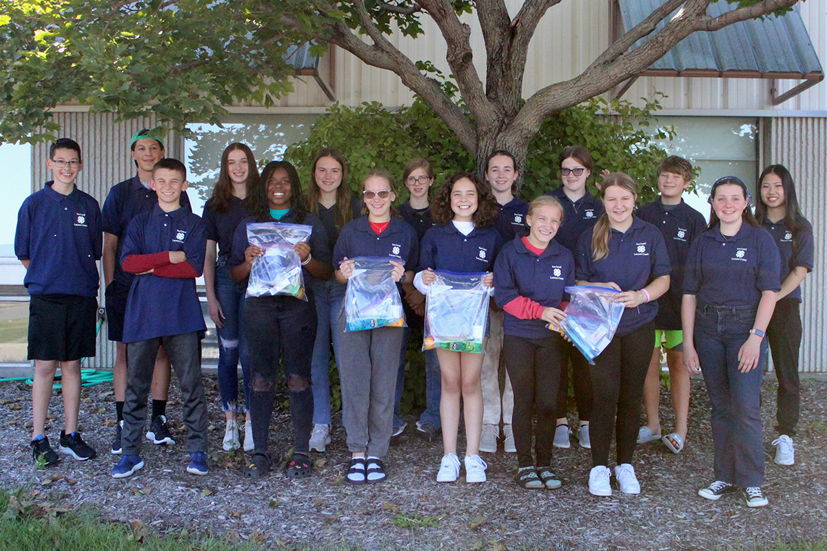 Teen Council members holding hygiene kits for the People's City Mission.