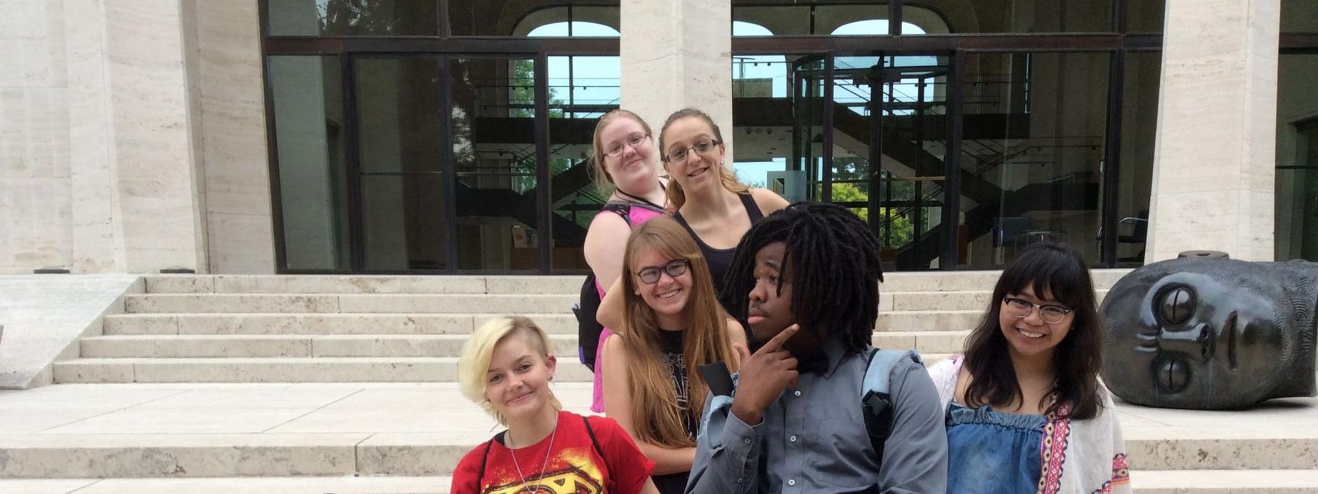 A group of young writers camp students in front of the Sheldon Art Gallery.