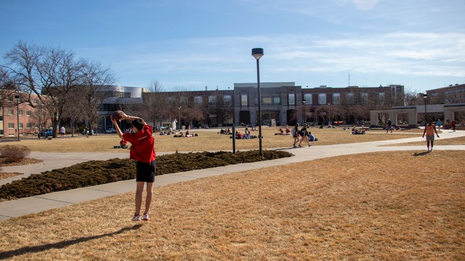 Students play catch with a football on the Meier Commons Green space. [Student Affairs Marketing and Communication]