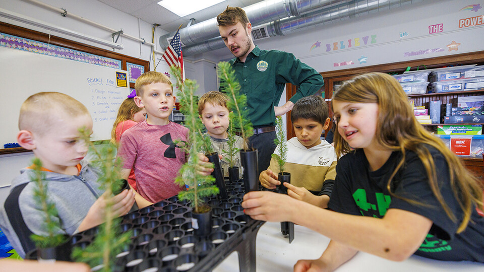 Jack Hilgert, conservation education coordinator for the Nebraska Forest Service, answers second-graders’ questions about their new Colorado blue spruce seedlings they will be growing.  Photo by Craig Chandler