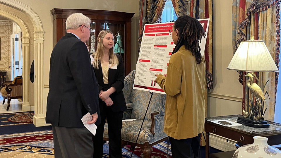 State Sen. Rick Holdcroft (left) speaks with seniors Lauren Behnk (center) and Meklit Aga (right), who presented the psychology project “Sense of Belonging and its Relationship with Student Success.” 