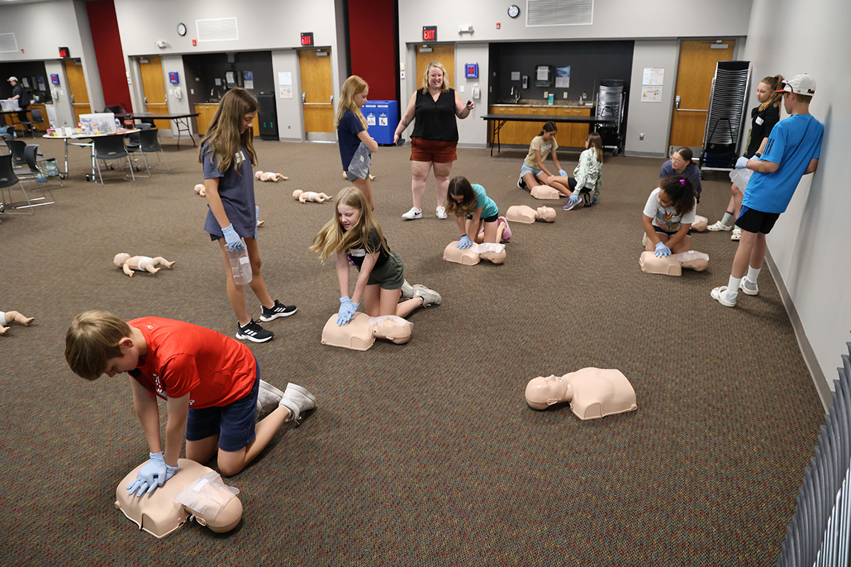 Youth at a previous Babysitting Training practicing CPR.