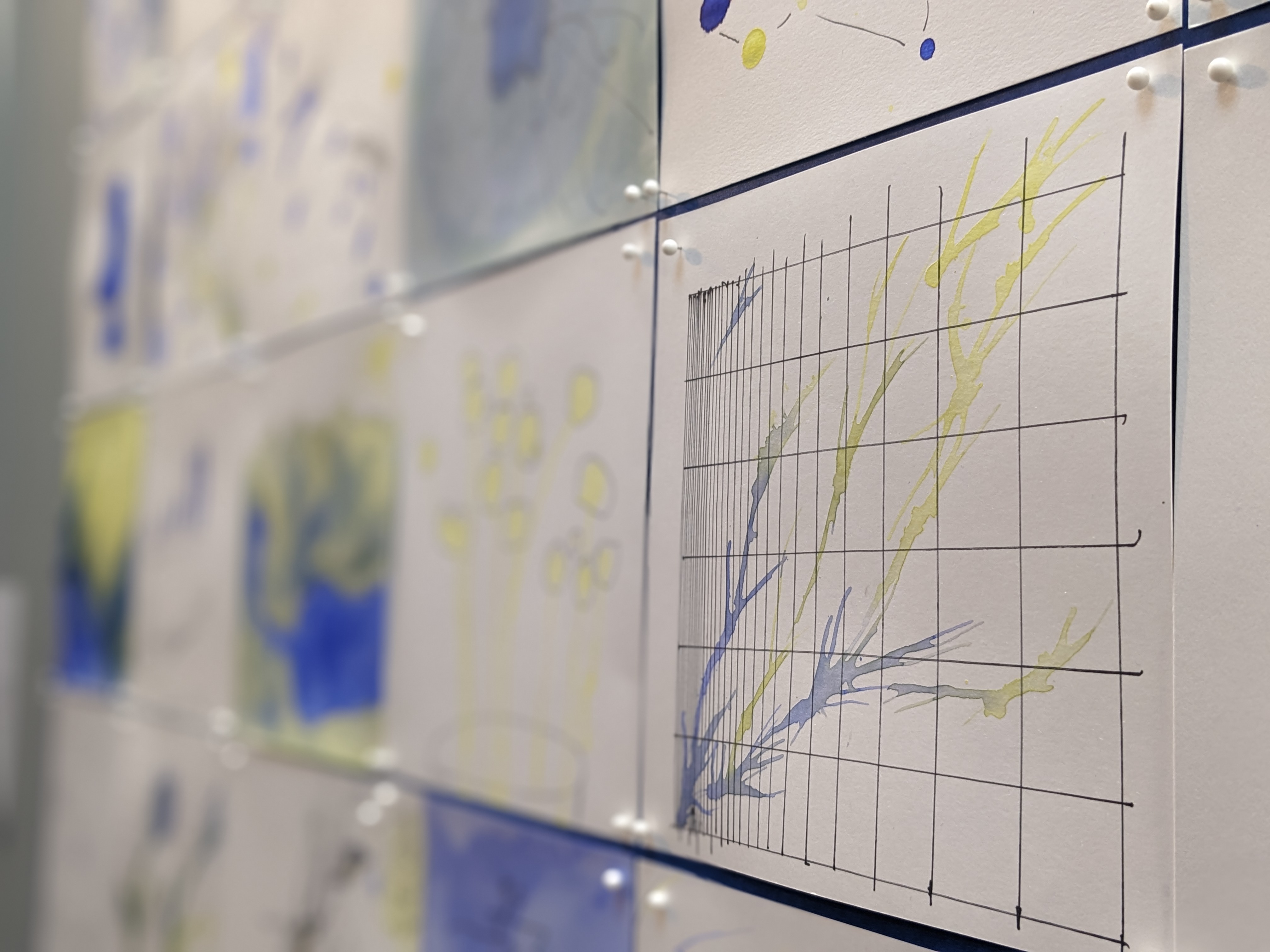 Scientists at the Conference on Biological Stoichoimetry created 8X8 paintings with blue and yellow watercolors and pipettes. The Constellation Studios gallery in Lincoln displayed the paintings as a mosaic. Photo courtesy of Elyse Watson