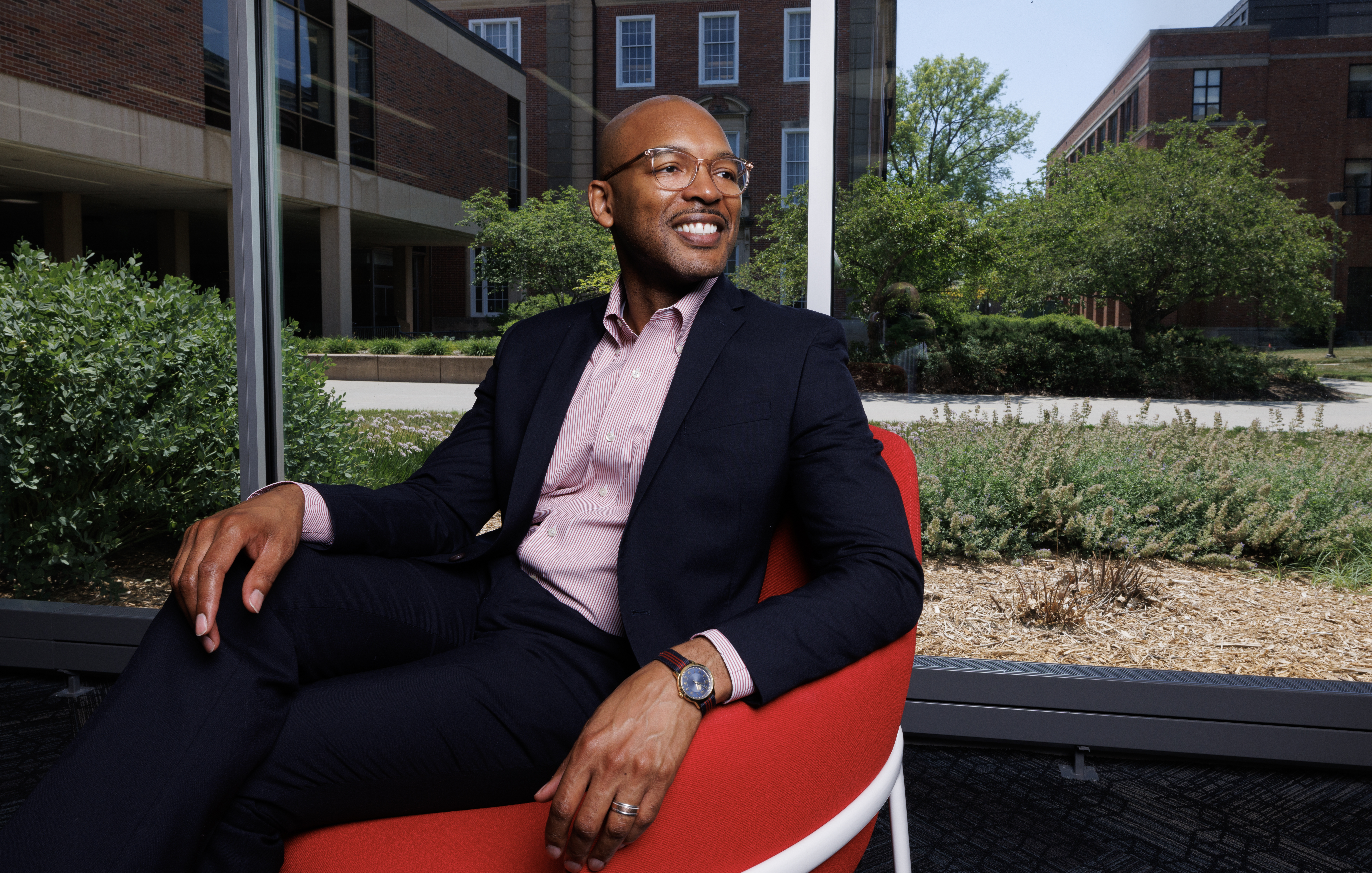 Vice Chancellor Marco Barker sitting on red chair 