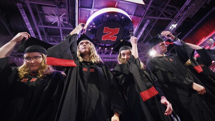 Kimberly Osborn, Kaylee Pekarek, Lisa Peterson and Scott Peterson move their tassels at the conclusion of the graduate and professional degree ceremony May 17.