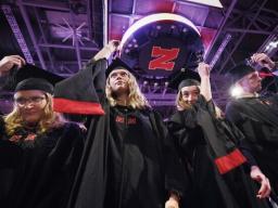 Kimberly Osborn, Kaylee Pekarek, Lisa Peterson and Scott Peterson move their tassels at the conclusion of the graduate and professional degree ceremony May 17.