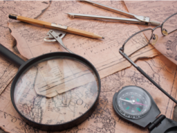 Map with compass, pencil, magnifying glass and eyeglasses on it