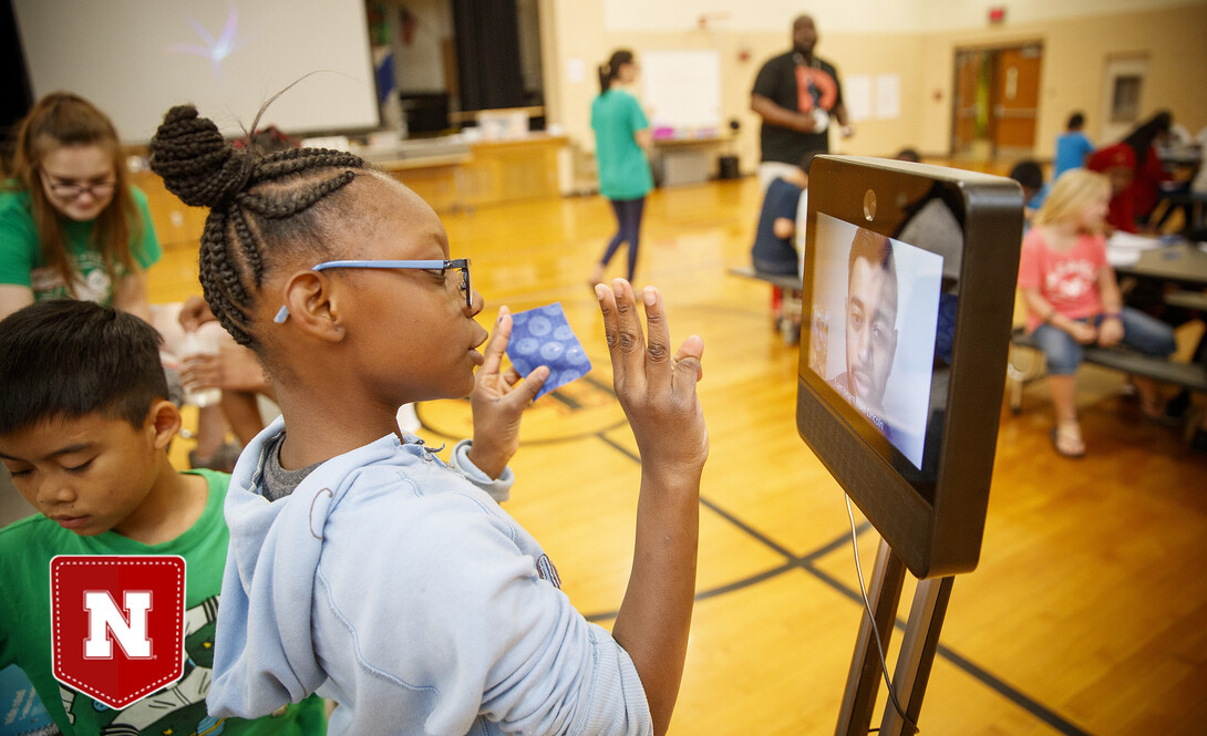 Ani'a Morris-Gordon interacts with Soham Patel using Beam technology to remote teach the class about nano technology and nano treated fabrics for Omaha school children in 2019. (Photo by Craig Chandler | UCOMM)