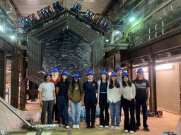 RENEW Pathway Summer School students from the Fermilab and Brookhaven National Laboratories Summer School Exchange Program in 2023 stand in front of the detector of the MINERvA experiment at Fermilab.