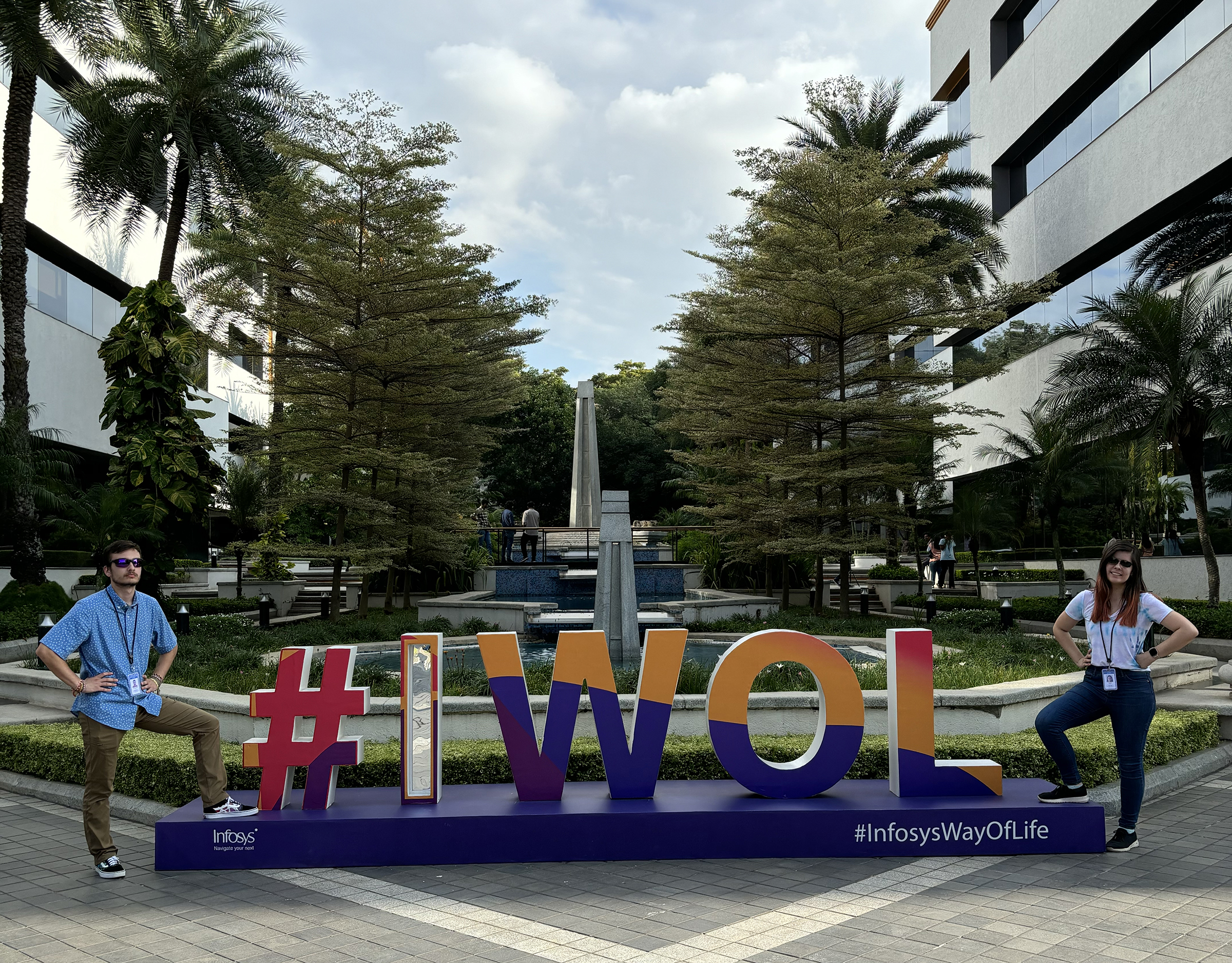 Charles Major and Megan Kolbe stand in front of the #IWOL (Infosys Way of Life) sign on the Infosys campus in India. Photo courtesy of Charles Major.