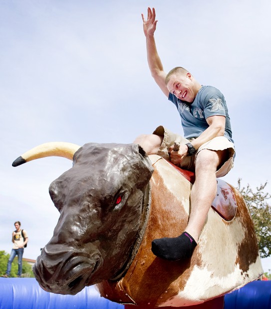 Cole VonDerOhe of Norfolk keeps a tight grip while riding a mechanical bull on Tuesday, April 10, 2012, on the north side of the Nebraska Union. The event, Husker Food Connection, was a combination of fun, food and learning as ag students from UNL looked 