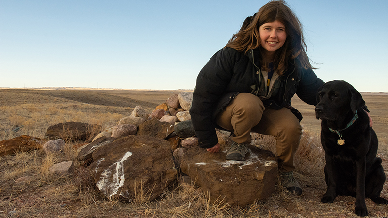 Emma Balunek and her dog, Coral, at a prairie rock pile.