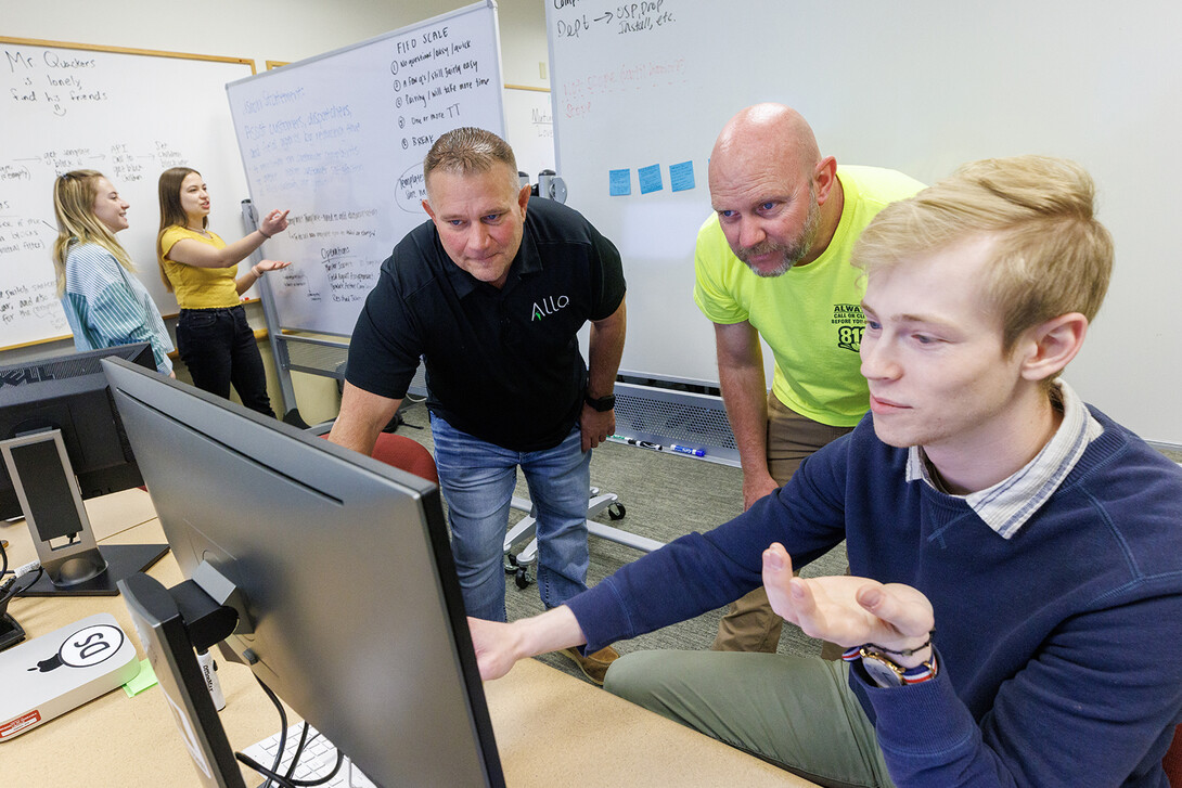 Erik Konnath (right) talks with ALLO representatives, Ed Jarrett and Jon McHenry (in yellow T-shirt) as they discuss a Raikes School Design Studio project in 2023.