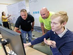 Erik Konnath (right) talks with ALLO representatives, Ed Jarrett and Jon McHenry (in yellow T-shirt) as they discuss a Raikes School Design Studio project in 2023.