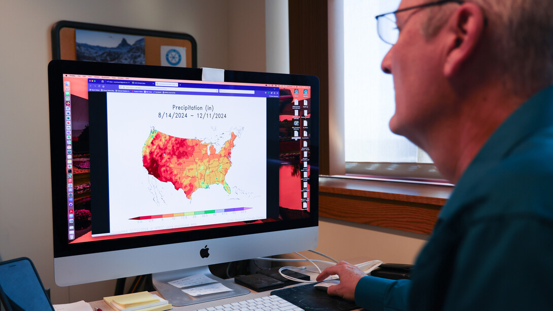 William Sorensen, senior applications/systems programmer for the High Plains Regional Climate Center, reviews an Applied Climate Information System map. Photo by Russell Shaffer | IANR Media 