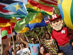 Herbie Husker with students holding flags from their countries. 