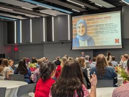 Furqan Mahdi, a 2024 Student Luminary Award recipient, accepts the award during the awards program, surrounded by attendees celebrating the achievement.