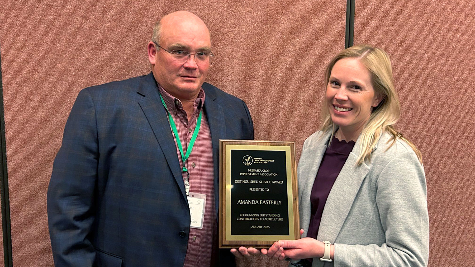 Chris Cullan, of Cullan Farms Seed (left), awards Amanda Easterly the Nebraska Crop Improvement Association’s Distinguished Service Award at the NCIA awards banquet during their annual Seed Improvement Conference Jan. 14 in Kearney.