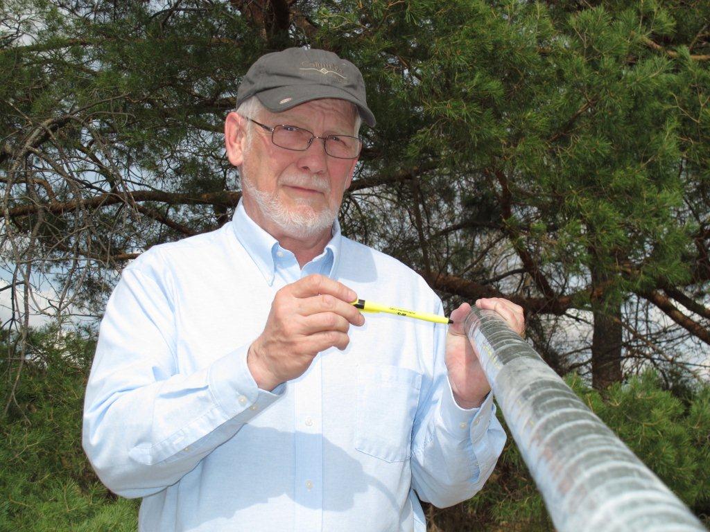 University of Nebraska-Lincoln geoscientist Steve Sibray points to an electrode that puts current into a wellbore using an eight-foot borehole geophysics tool. 