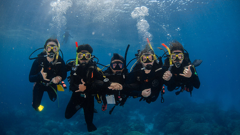 Nebraska students take a deep dive with a guide (at center) at the Great Barrier Reef by Australia. Photo courtesy of Alaina Dierman