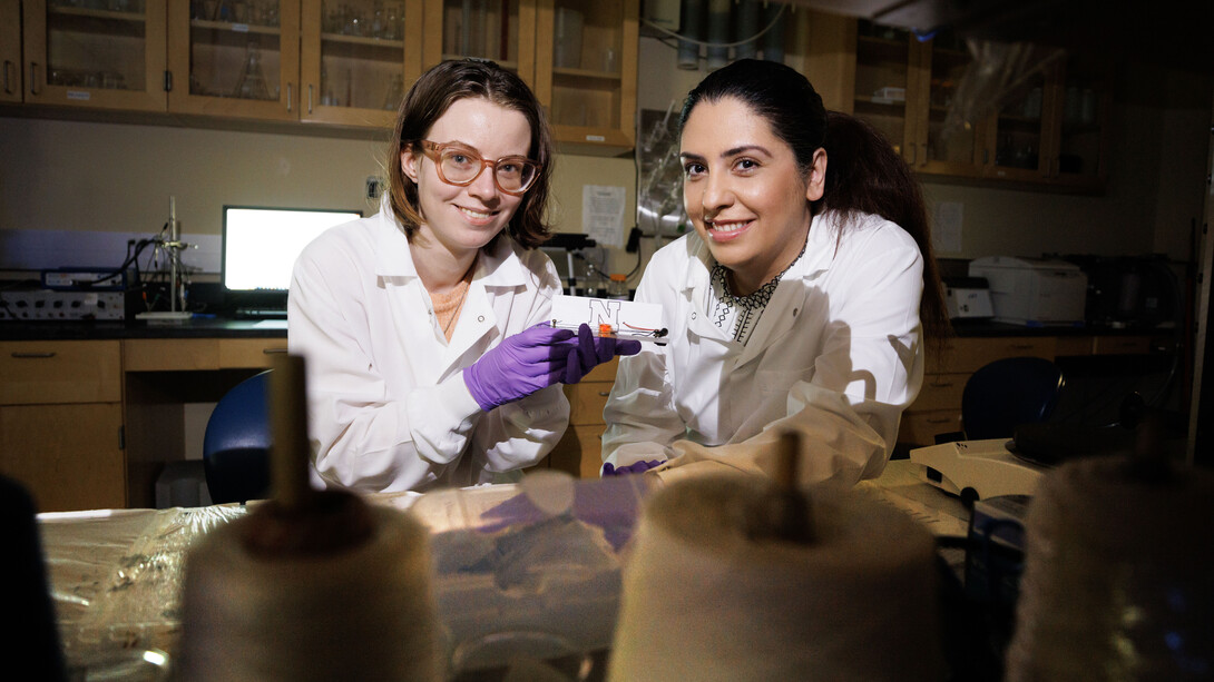 Alyssa Grube (left) and Mona Bavarian hold a textile-based supercapacitor. (University Communication photo)