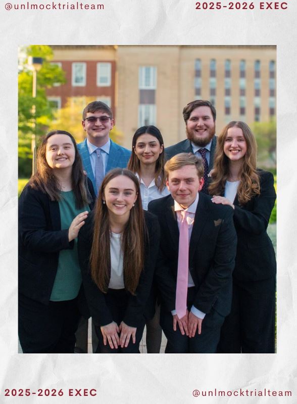 7 individuals standing as a group in front of Love Library