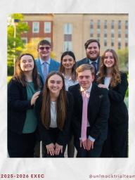 7 individuals standing as a group in front of Love Library