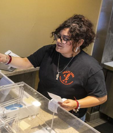 Vianka Curiel giving a receipt to a customer.