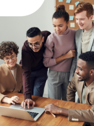 Picture of five people standing around a computer looking at the screen