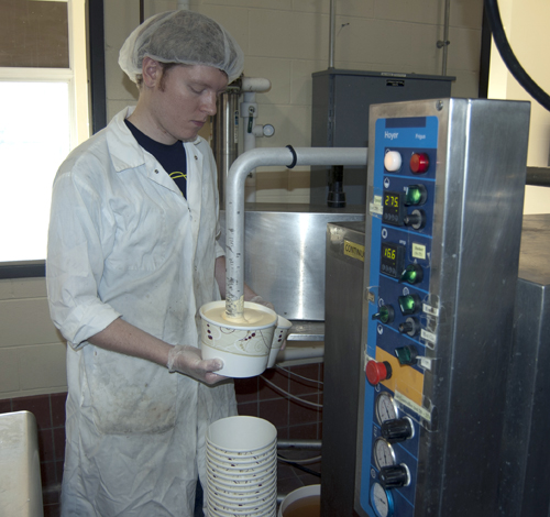 Dairy Plant worker and UNL student Russell Parde fills a container with Lemon Custard ice cream.