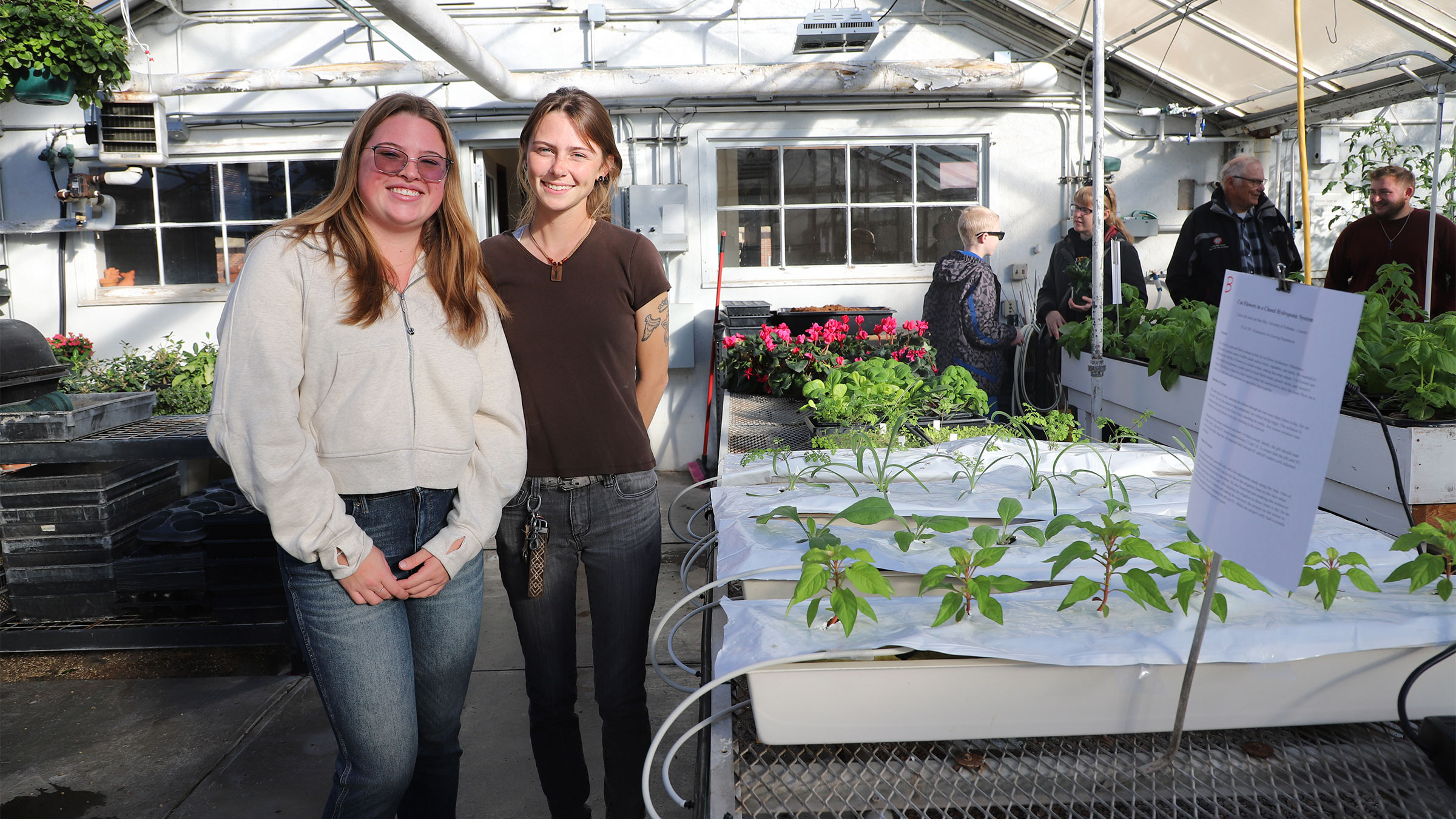 Undergraduate students Caitlin DeCoster (left) and Sara May in the Hydroponics for Growing Populations course demonstrate their hydroponic system at the open house Nov. 21, 2024.