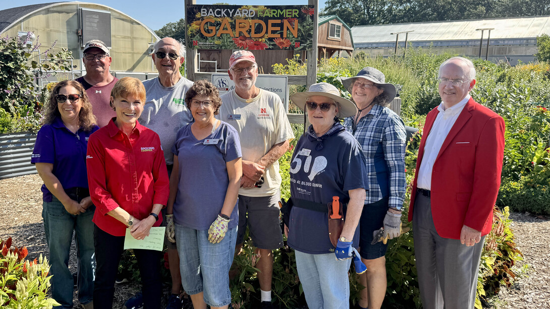 Terri James, Nebraska Extension Master Gardener Volunteer program coordinator (left), and a team of Master Gardener Volunteers pause for a photo in the Backyard Farmer Garden with Kim Todd (front row, second from left) and Jeffrey P. Gold (right).