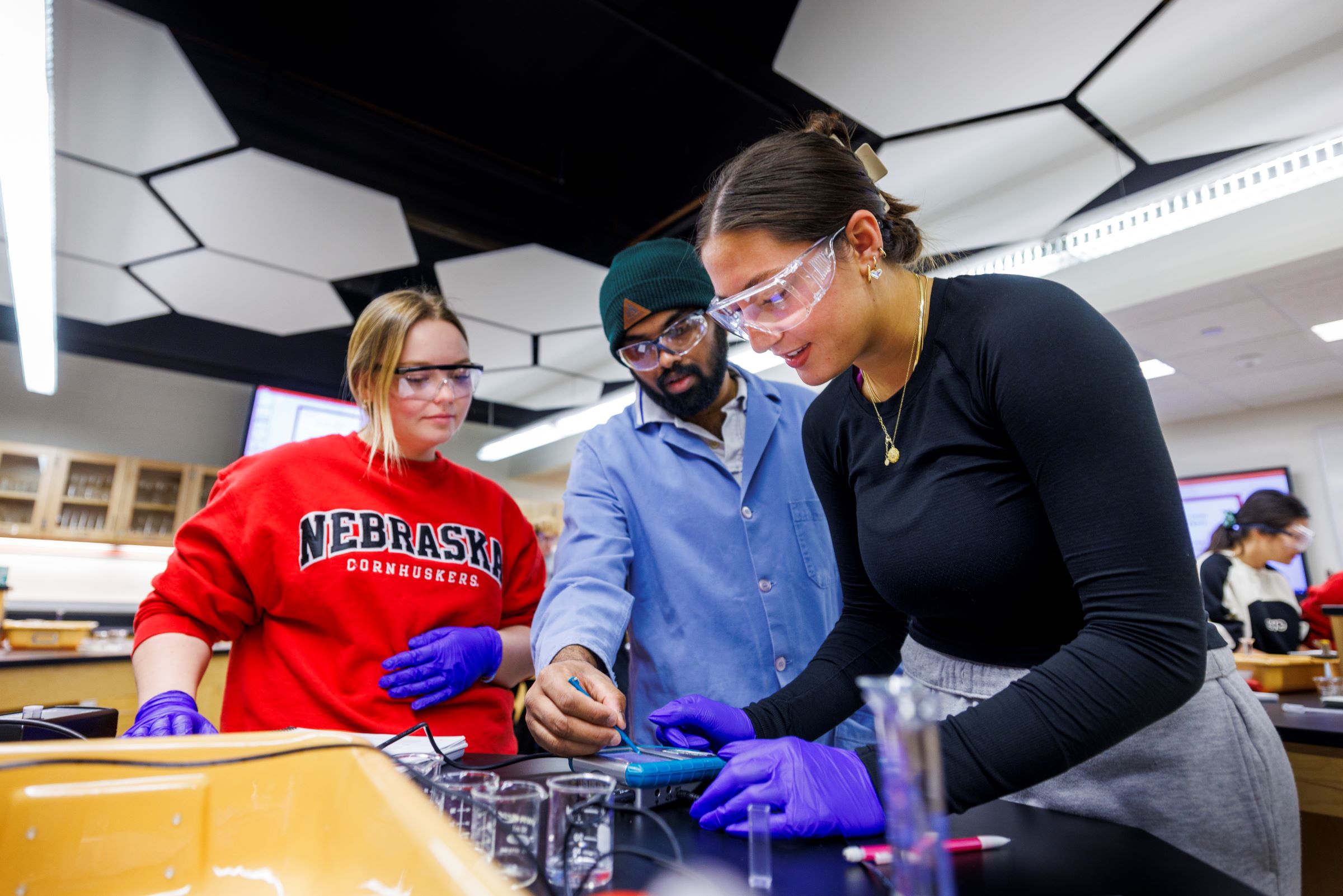 Three students working on a chemistry experiment.