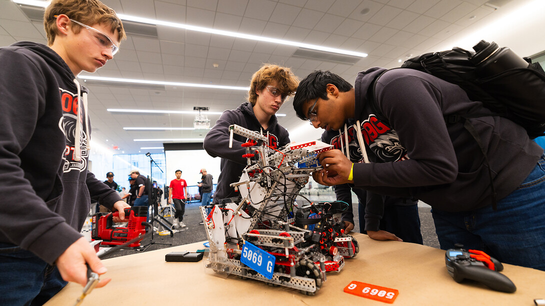 Members of the Ziptide team from Millard North High School attach color-coded tags to their robot before a semifinal round in the VEX Robotics competition. 