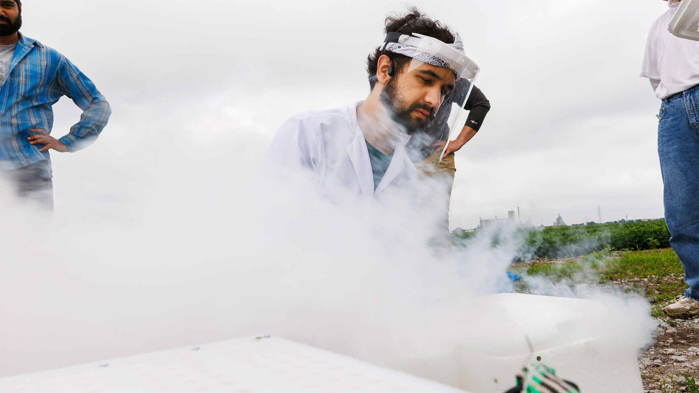 Jon Turkus makes a fog as he combines dry ice from several portable field kits while field phenotyping corn plant DNA in James Schnable&rsquo;s field northeast of 84th and Havelock. 