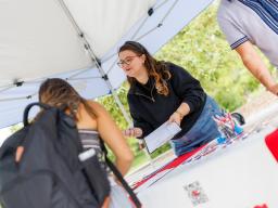 Maggie Nielsen with the Husker Vote Coalition provides voter registration information to a student.